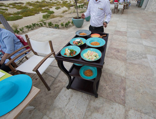 waiter with food tray on a trolley in a restaurant