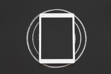 Technology and innovation in business planning and growth. Tablet on target drawn in chalk....
