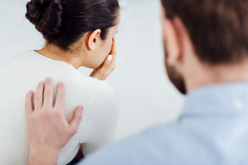 back view of man consoling woman during therapy meeting