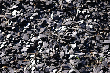 Zu einem Geröllbett aufgeschichteter Schiefer für die Gartendekoration. ..
