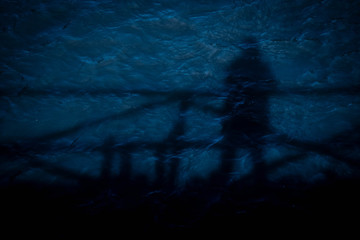 Shadow of person alone standing on the bridge and reflection on the river. Lonely concept.