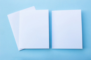 Blank portrait mock-up paper. brochure magazine isolated on blue, changeable background / white paper isolated on light blue paper.