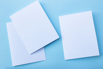 Blank portrait mock-up paper. brochure magazine isolated on blue, changeable background / white paper isolated on light blue paper.