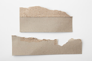 Brown corrugated texture paper torn on white background. rip of cardboard sheet used as a...