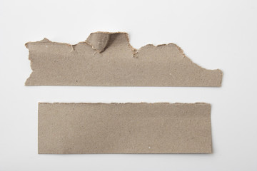 Brown corrugated texture paper torn on white background. rip of cardboard sheet used as a...