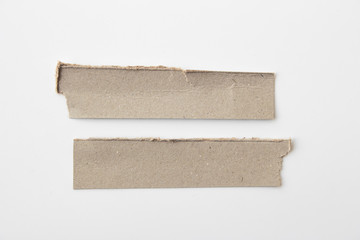 Brown corrugated texture paper torn on white background. rip of cardboard sheet used as a background .
