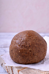 Dough ball of rye whole grain flour against the white wooden background