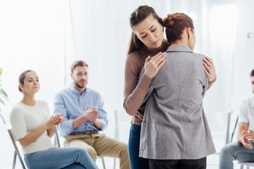 Fototapeta na wymiar selective focus of women hugging during group therapy session