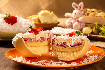 Gourmet easter egg, stuffed with coconut cream, strawberry and chocolate. Easter egg with pudding cream, Easter dessert. Easter concept.