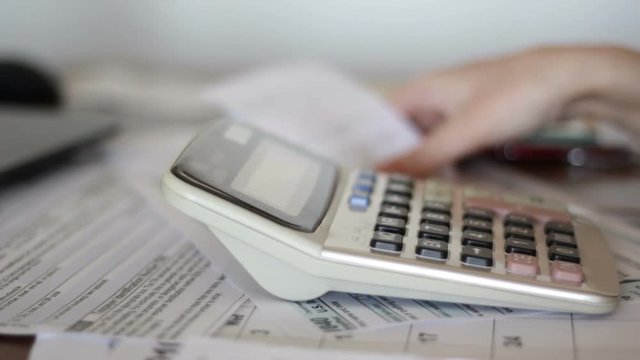 Woman calculate domestic bills at home for tax purposes