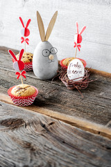 Lächelnder Hase mit Muffins und Osterei