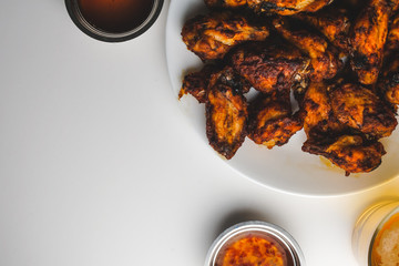 Chicken wings with chili sauce on white background.