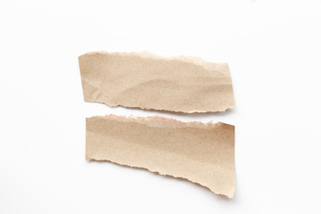 Brown corrugated texture paper torn on white background. rip of cardboard sheet used as a background .