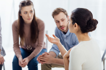 selective focus of woman gesturing with hand during group therapy session