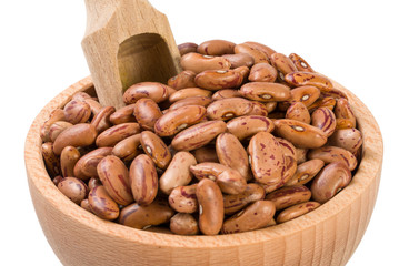 Pinto bean in wooden bowl and scoop isolated on white background. nutrition. bio. natural food ingredient.