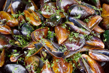 Cooked mussels with greens on a plate, seafood, soft focus