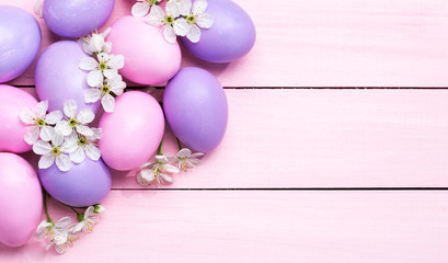 Easter eggs and  white flowers (Cherry blossom ) on pink wooden table.