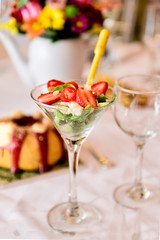 vegetable salad lettuce and  strawberries, finger food, fit food, elegant fruit salad in a martini glass, delicious strawberries and fresh greens for a party, healthy food arrangement for an event