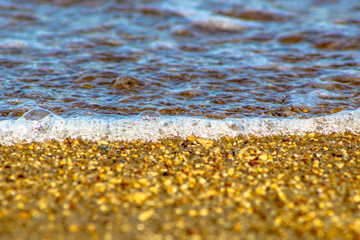 Fototapeta na wymiar Sand and waves in beach with selective focus