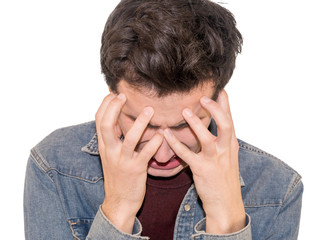 Portrait of  despair young man closed face by two hands. Isolate