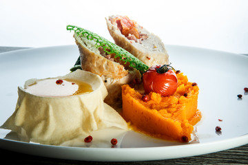 macro dissected stuffed chicken with pumpkin puree against white background
