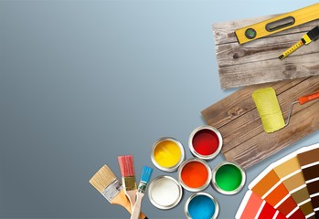 Paint brushes and paint cans for  repair on wooden background