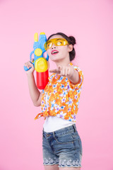 Happy girl holding a pink background water gun.