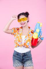 Happy girl holding a pink background water gun.