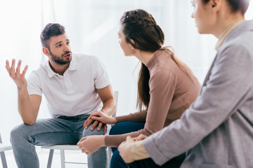 women and man sitting and having discussion during group therapy session