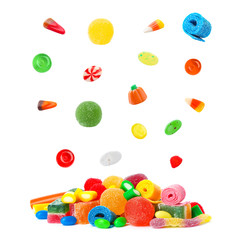Fototapeta na wymiar Many different candies falling into pile on white background