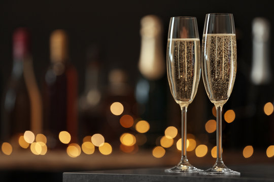 Glasses of champagne on table against blurred background. Space for text