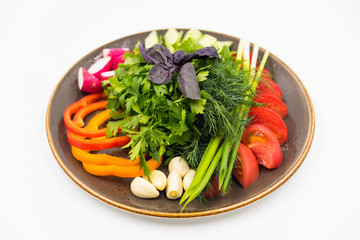 Cutting fresh vegetables on the white plate on white background.