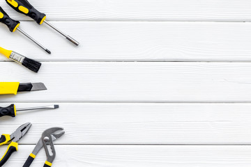 constructor desk with set of building implements and brushes white wooden background top view mock...