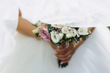 the bride holds a wedding bouquet in her hands