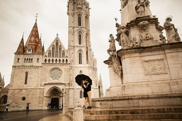 Fototapeta premium Hugged loving couple by the Fisherman's Bastion in Budapest, Hungary on a rainy day