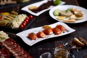 salmon rolls with cheese on a white plate