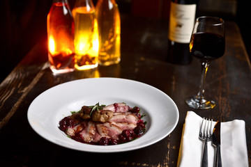 fried duck meat with berry sauce on a white plate