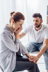 man consoling crying woman during therapy meeting