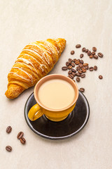 A cup of fresh coffee with croissant. The concept on a stone background.
