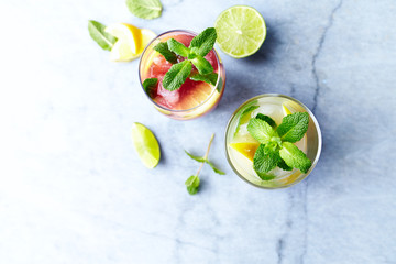 Home made Apple-Lemon and Raspberry-Lemon Lemonade with mint leaves and ice. Summer fruit drinks. Copy space