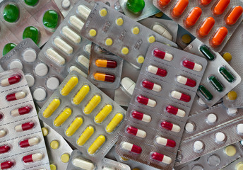  Medicaments in blisters, arranged in a pile in a chaotic manner. Multicolored pills and capsules closeup.