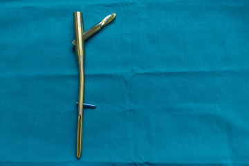 an explanted titanium femur nail on a green surgical drape