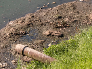 Fototapeta premium Concrete pipe discharges sewage into Pinheiros River in Sao Paulo city
