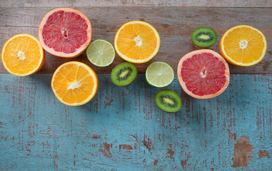 Pattern of citrus (orange, grapefruit, lemon, lime) fruit and kiwi on the wooden background