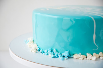 Cake of the marine, sea theme, decorated with blue mirror glaze on a white background.