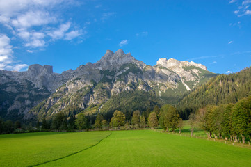 Fototapeta na wymiar Austrian Verfenveg village Alps mountains autumnal scenery with fog, green meadows and rocks