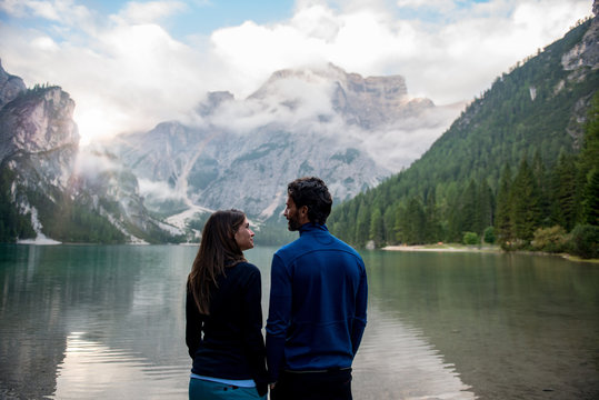 Couple standing near lake against mountain