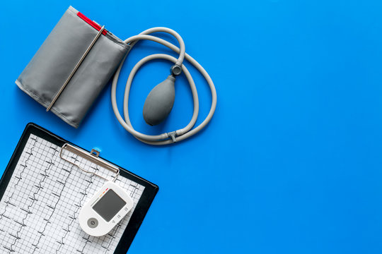 pulsimeter on the desk of the doctor for diagnostics of cardiac disease on blue background top view space for text