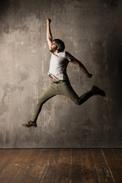 Man jumping against concrete wall