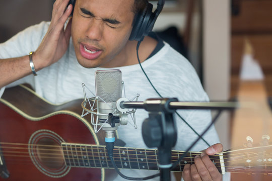 Man singing with guitar in studio